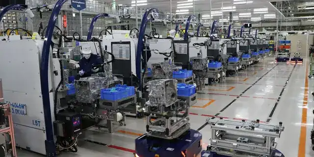 modern manufacturing factory floor with engineer checking production line