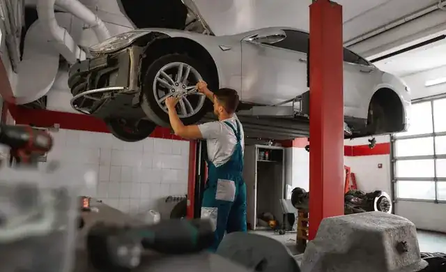 professional mechanic working on a car in a clean modern auto workshop