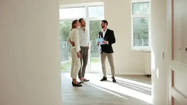 real estate agent showing a bright modern apartment to clients