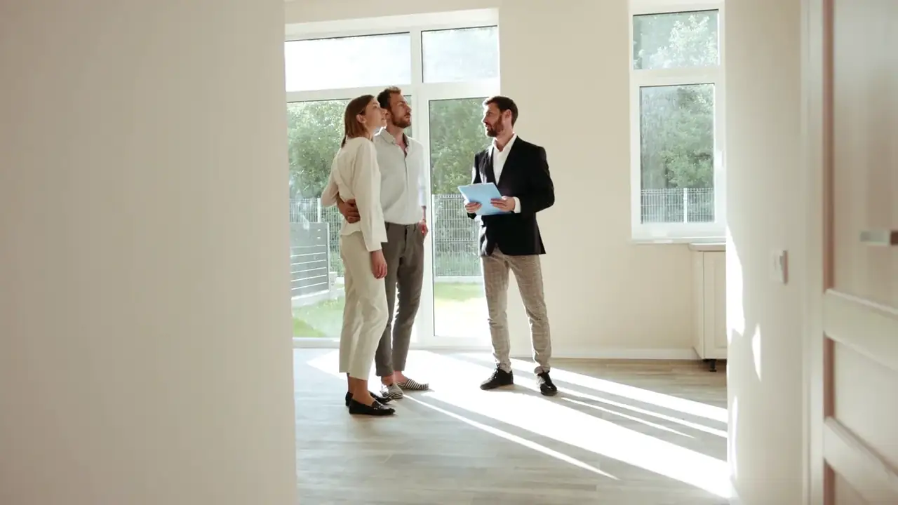 real estate agent showing a bright modern apartment to clients