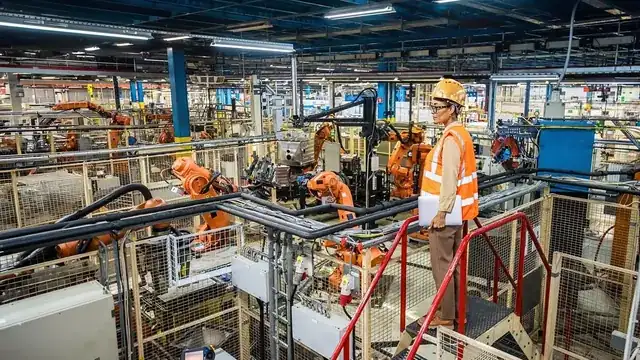 modern manufacturing factory floor with engineer checking production line