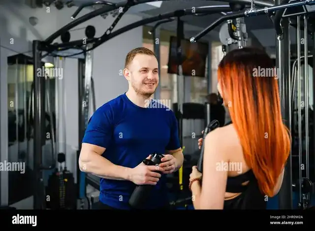 modern gym interior with personal trainer coaching a client