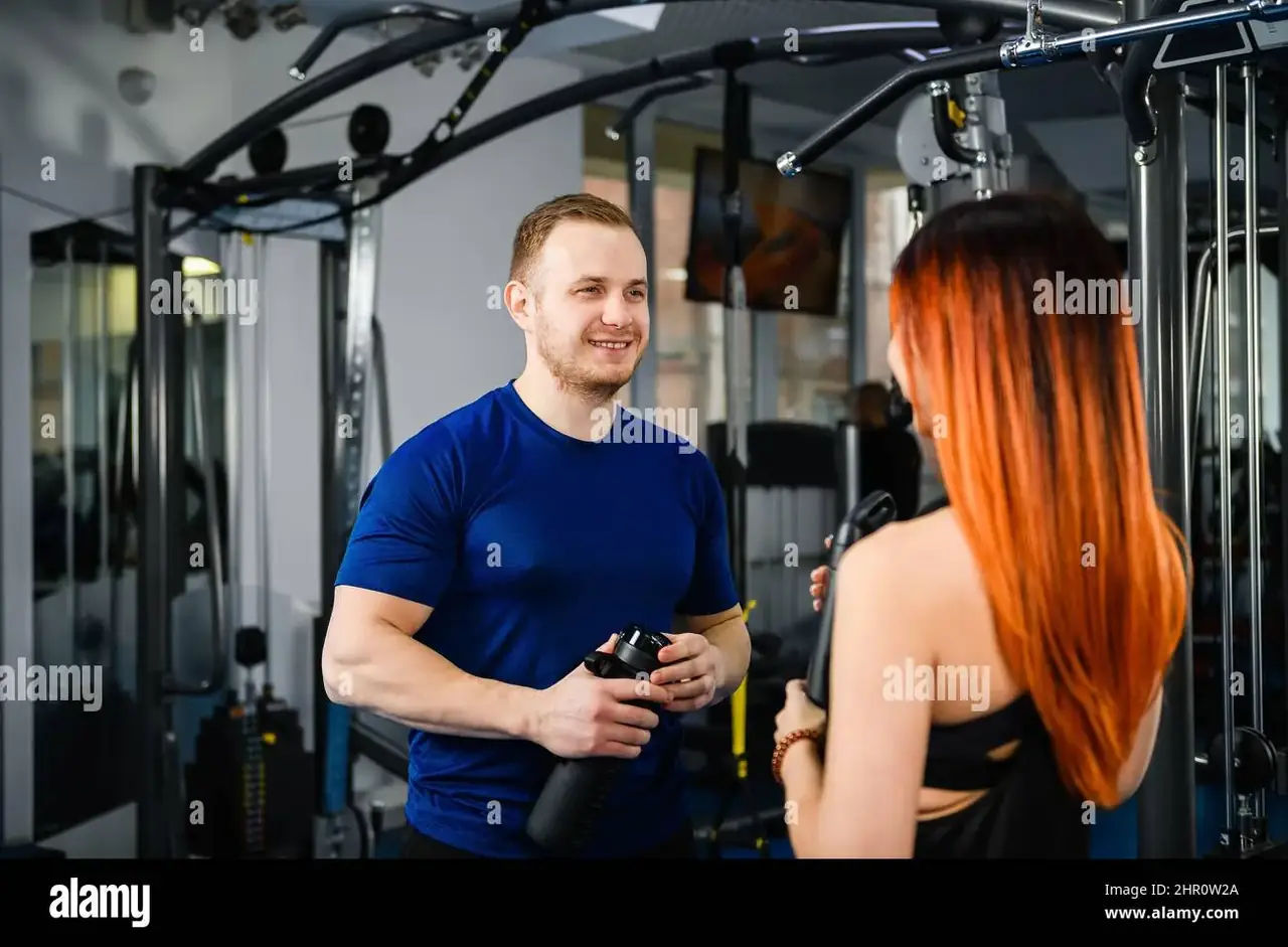 modern gym interior with personal trainer coaching a client