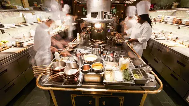 busy modern restaurant interior with chef plating gourmet dishes