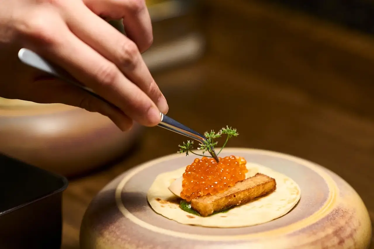 busy modern restaurant interior with chef plating gourmet dishes