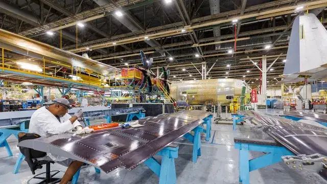 modern manufacturing factory floor with engineer checking production line