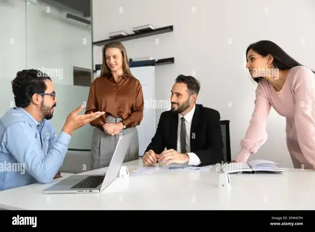 startup team collaborating around laptops in a bright modern office