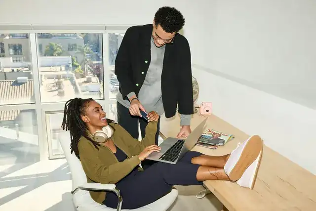 startup team collaborating around laptops in a bright modern office